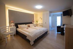 a bedroom with a large bed and a living room at Hotel Garni Zum Grünen Baum in Hövelhof