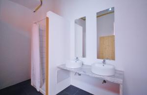 Baño con 2 lavabos y espejo en Lemon Tree Urban Camping, en Faro