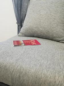 a book sitting on top of a couch with a pillow at Apartman Nada in Kornić