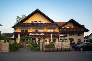 ein Hotel mit Blumen auf der Vorderseite eines Gebäudes in der Unterkunft Hotel Garni Zum Grünen Baum in Hövelhof