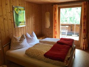 a bedroom with two beds and a large window at Berghaus Außergschlöß in Matrei in Osttirol