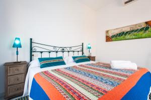 1 dormitorio con 1 cama con colcha colorida en Singular Pilatos, en Sevilla