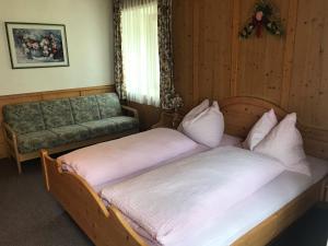 1 Schlafzimmer mit 2 Einzelbetten und einem Sofa in der Unterkunft Gasthof zum Gamsjäger in Sankt Nikolai im Sölktal