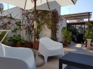 a patio with a white chair and an umbrella at B&B Torrente Antico in Trani