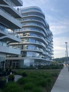 a large glass building with a sidewalk in front of it at Ocean View Apartment in Aarhus