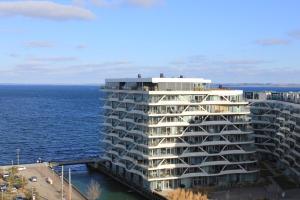 a large white building next to the ocean at Ocean View Apartment in Aarhus