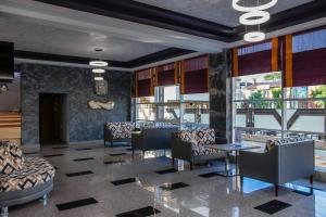 a lobby with chairs and tables and windows at Olimp Resort Hotel All Inclusive in Anapa
