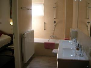 ein Badezimmer mit einem Waschbecken und einer Badewanne in der Unterkunft Liry's Home in Tongeren