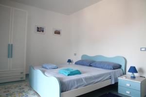a bedroom with a bed with blue pillows on it at Appartamento Malvasia in Canneto