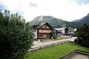 une maison dans un village avec des montagnes en arrière-plan dans l'établissement Alpenflair Ferienwohnungen Whg 106, à Oberstdorf