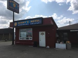 a building with a sign that reads winnies motel furniture snacks at Winkys Motel in Estevan