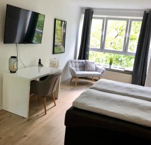 Schlafzimmer mit einem Bett, einem Schreibtisch und einem Stuhl in der Unterkunft Apartment H50 in Hannover