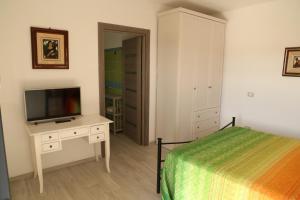 a bedroom with a bed and a flat screen tv at Mabell Guest House in Civitavecchia