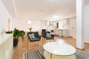 Una sala de estar con mesa y sillas y una cocina. en Montes Claros 26, en Granada