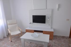 - un salon avec une télévision, une table et une chaise dans l'établissement Armonía Beach 104, à Arinaga