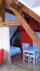 a room with a bed and a table in a attic at Le charme du château in Les Andelys