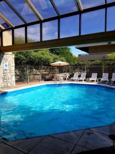 a swimming pool with blue water in a building at Days Inn & Suites by Wyndham Monroe in Monroe