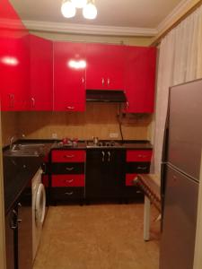 a kitchen with red cabinets and a stainless steel refrigerator at Jermuk Apartment in Jermuk