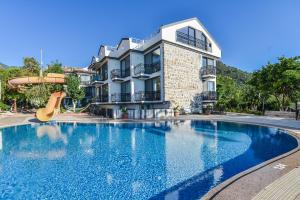 a swimming pool with a slide in front of a building at Seyir Village Hotel in Oludeniz