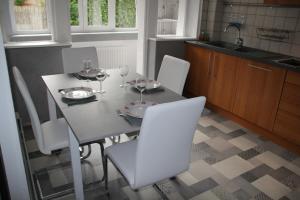 a kitchen with a table and chairs with wine glasses at Appartement T3 très calme - Le Bartholdi - Centre de Colmar in Colmar +11 photos