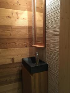 ein Holzbadezimmer mit einem Waschbecken und einem Spiegel in der Unterkunft Chalet La R'Batte in Sixt