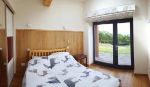 Schlafzimmer mit einem Bett und einer Glastür in der Unterkunft Wester Blackpark Farm in Inverness