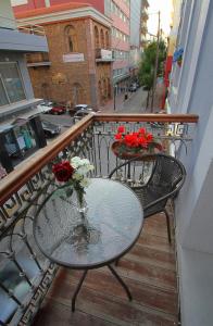 einen Glastisch mit Blumen auf dem Balkon in der Unterkunft Ionia rooms in Chios