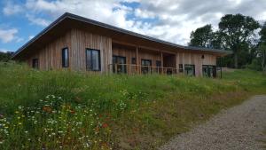a wooden house with a field of flowers in front of it at Wester Blackpark Farm in Inverness