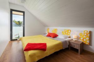 デンプキにあるDomki Morski Rajのベッドルーム1室(大型ベッド1台、黄色と赤の枕付)