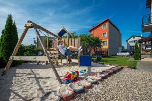 un niño se balancea en un patio de recreo en Willa Daniela - Chłapowo en Władysławowo