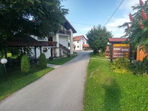 a road in a village with a house and a sign at House Pavlic in Grabovac