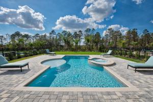 uma piscina com 2 espreguiçadeiras e um pátio em Chic Home with Private Pool near Disney World by Rentyl - 7706F em Orlando
