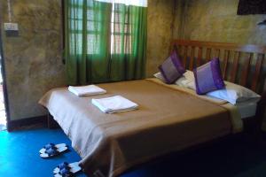 a bedroom with a large bed with towels on it at Tamarind Grand Resort Mae Sariang in Mae Sariang