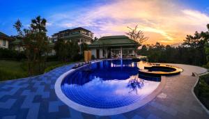a large swimming pool with a gazebo next to a house at Vivace Khaoyai in Mu Si