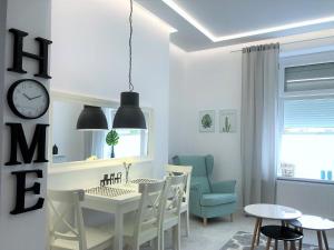 uma sala de jantar com mesa e cadeiras e um relógio em Apartament BellaPola 2 em Nysa