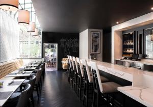 a restaurant with black walls and chairs and a bar at Chamberlain West Hollywood in Los Angeles
