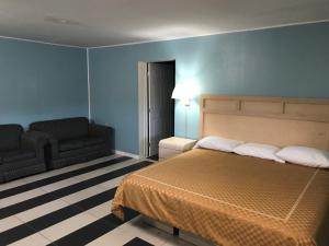 a bedroom with a bed and a chair and a couch at Apollo Inn - Cocoa in Cocoa