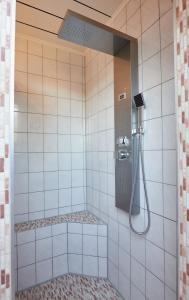 y baño con ducha de azulejos blancos. en Ferienwohnung Haaren, en Waldfeucht