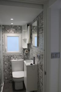 a bathroom with a toilet and a sink and a window at Apartamento Rural Zuri in Cotorrio