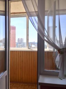 ノヴォシビルスクにある2-Bedroom Budget Flat in Gorskyの窓2つとカーテン付きの部屋