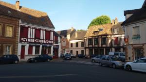 uma rua da cidade com carros estacionados na rua em Le charme du château em Les Andelys