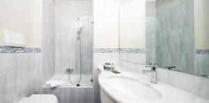 a bathroom with a sink, toilet and bathtub at Garda Hotel in Montichiari
