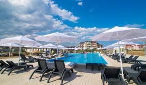 a pool with chairs and umbrellas next to a resort at WELCOME summer in Zatoka