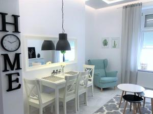 a dining room with a table and chairs and a clock at Apartament BellaPola 2 in Nysa