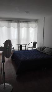 a bedroom with a bed and a table and a window at Aparta estudio en Ibagué in Ibagué