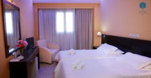 um quarto de hotel com uma cama e uma cadeira em Grand Hotel Dentro em Konitsa