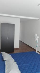 Schlafzimmer mit einem blauen Bett und einem Ventilator in der Unterkunft Aparta estudio en Ibagué in Ibagué