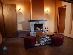 a living room with a fireplace and a table and chairs at Grand Hotel Dentro in Konitsa