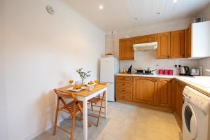 een keuken met een tafel en een witte koelkast bij PREMIER - Ashgrove Apartment in Coatbridge