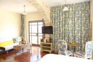 a room with a bed and a couch and a tv at B&B - Racheli Bar-Lev in Had Nes